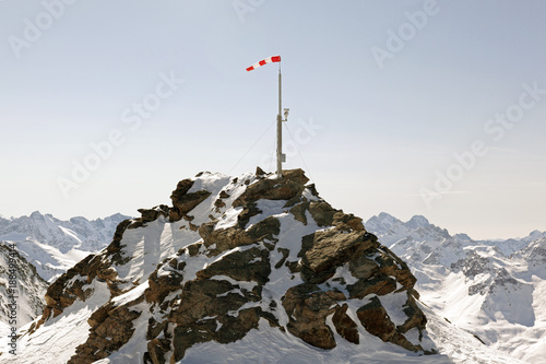 Fototapeta Widok góra śnieżna góra i wiatrowa flaga i kamera bezpieczeństwa na nim w alps Switzerland
