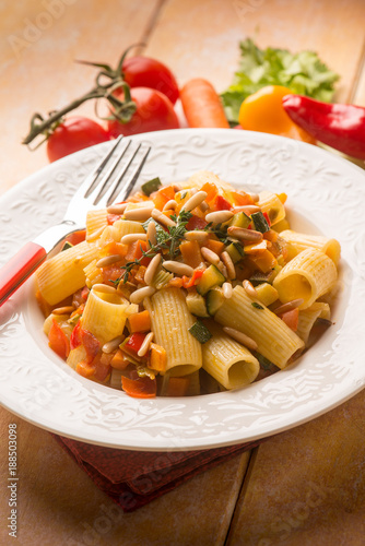 pasta with mixed vegetables and pine nuts, selective focus