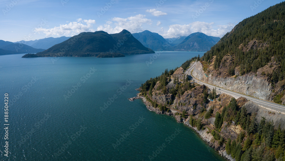 Aerial view of Sea to Sky Highway in Howe Sound during a vibrant sunny summer day. Taken North of Vancouver, BC, Canada.