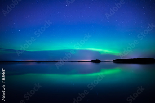Northern lightd dancing over calm lake in Farnebofjarden national park in Sweden. © Conny Sjostrom