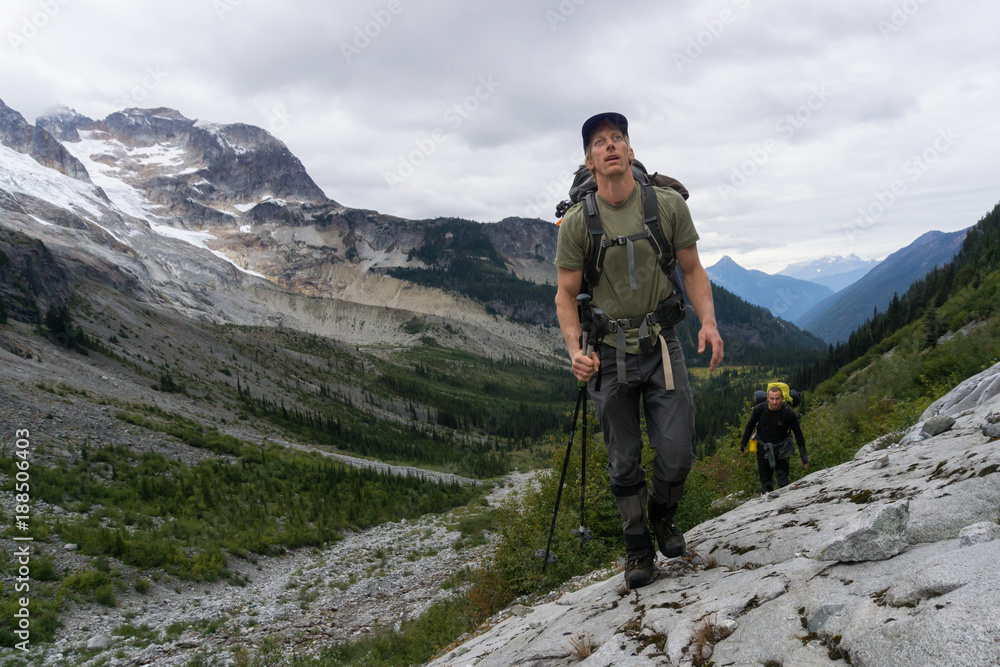 Couple adventurous friends are hiking in the wilderness on rocky mountain terrain. Taken Northeast of Seattle, Washington, United States of America.
