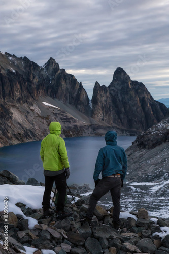 Couple adventurous friends are hiking in the wilderness on rocky mountain terrain. Taken Northeast of Seattle, Washington, United States of America. 