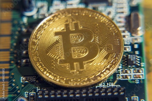 Golden bitcoin coin lying on green computer keyboard, cryptocurrency bubble investing concept