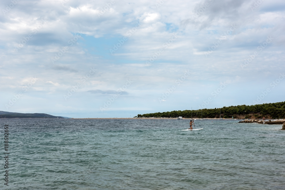 Fototapeta premium Adult man floats with the surfboard on the sea