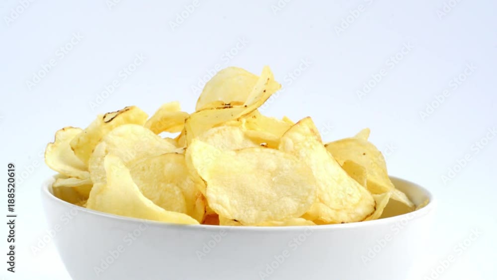 Hands taking potato chips from a bowl Hands taking potato chips from a bowl