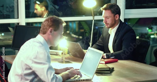 Business partners in the evening office. Developing new marketing strategy. Late work overtime concept.