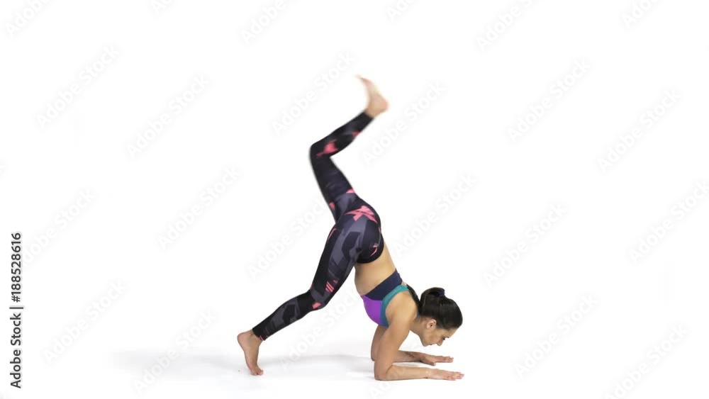 Young attractive woman practicing yoga doing Vrschikasana, Scorpion pose in full length, isolated over white studio background Young attractive woman practicing yoga doing Vrschikasana, Scorpion pose in full length, isolated over white studio background