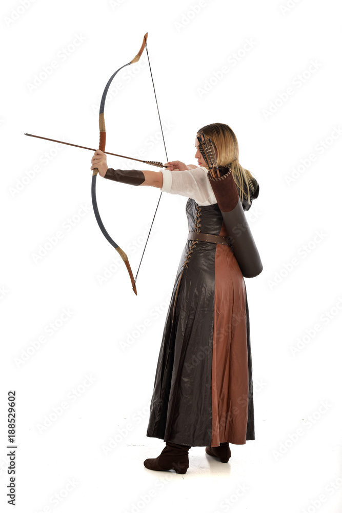full length portrait of girl wearing brown fantasy costume, holding a bow and arrow, on white studio background. full length portrait of girl wearing brown fantasy costume, holding a bow and arrow, on white studio background.
