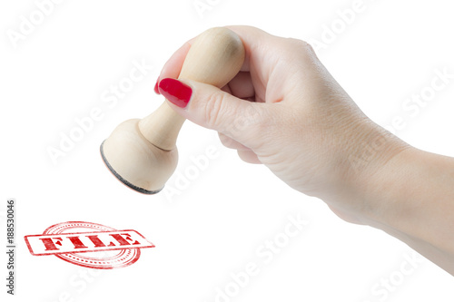 Hand holding a rubber stamp with the word file