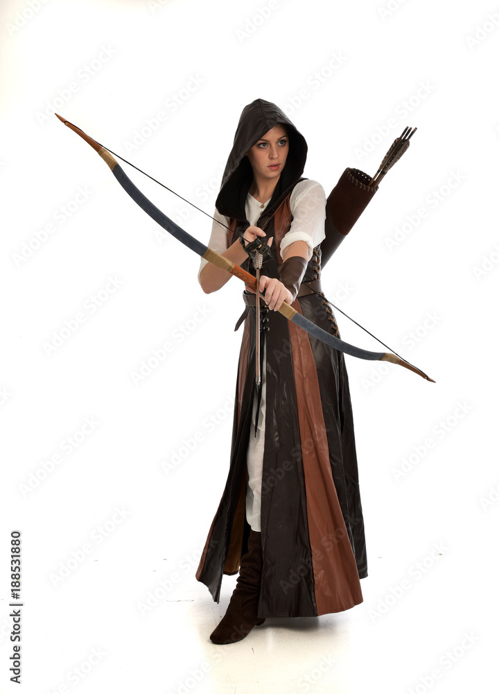 full length portrait of girl wearing brown fantasy costume, holding a bow and arrow, on white studio background. full length portrait of girl wearing brown fantasy costume, holding a bow and arrow, on white studio background.