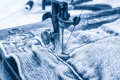 Retro sewing machine and item og clothing closeup. Toned image