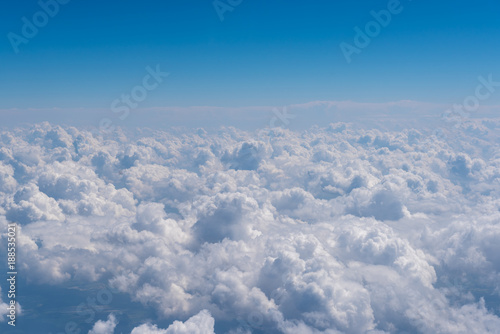 Blue sky and clouds, view from airplane window. Nature background, aerial view.