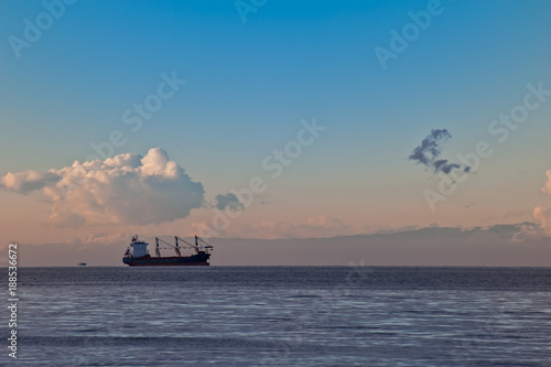 Seascape with ship at sunset with clouds. © Franco Nadalin