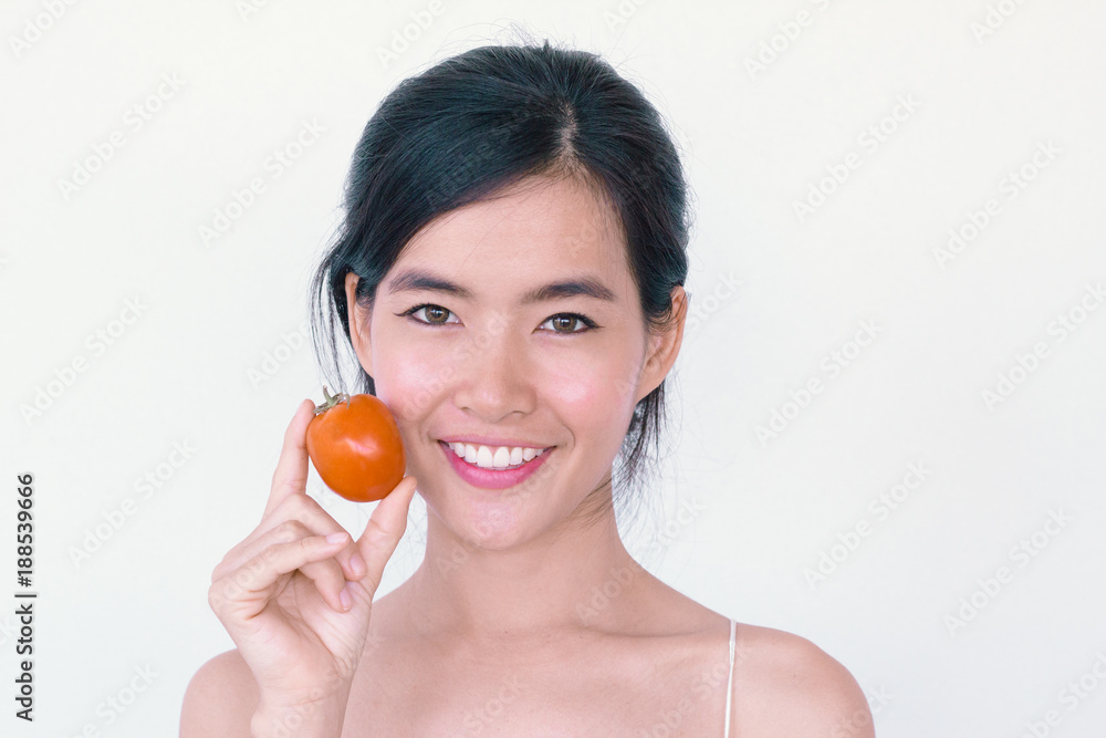 Beauty lycopene Skincare concept- Young Asian woman after shower smiling holding red tomato Beauty lycopene Skincare concept- Young Asian woman after shower smiling holding red tomato