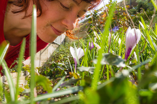 Woman smelling white crosus on grass photo