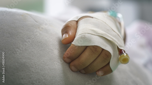 Children give saline solution in bed in hospital.