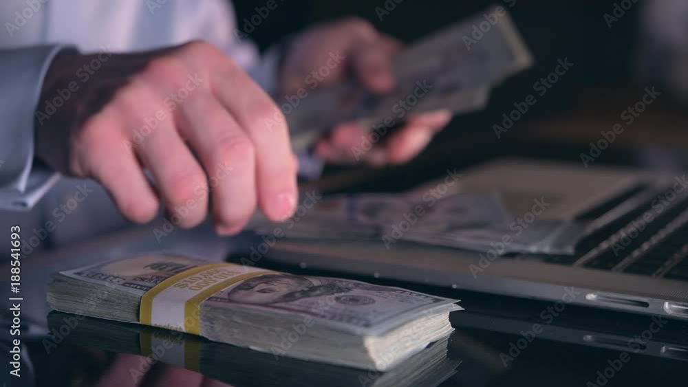 Caucasian Businessman Counting Hard Earned Money on His Glassy Office Desk Caucasian Businessman Counting Hard Earned Money on His Glassy Office Desk