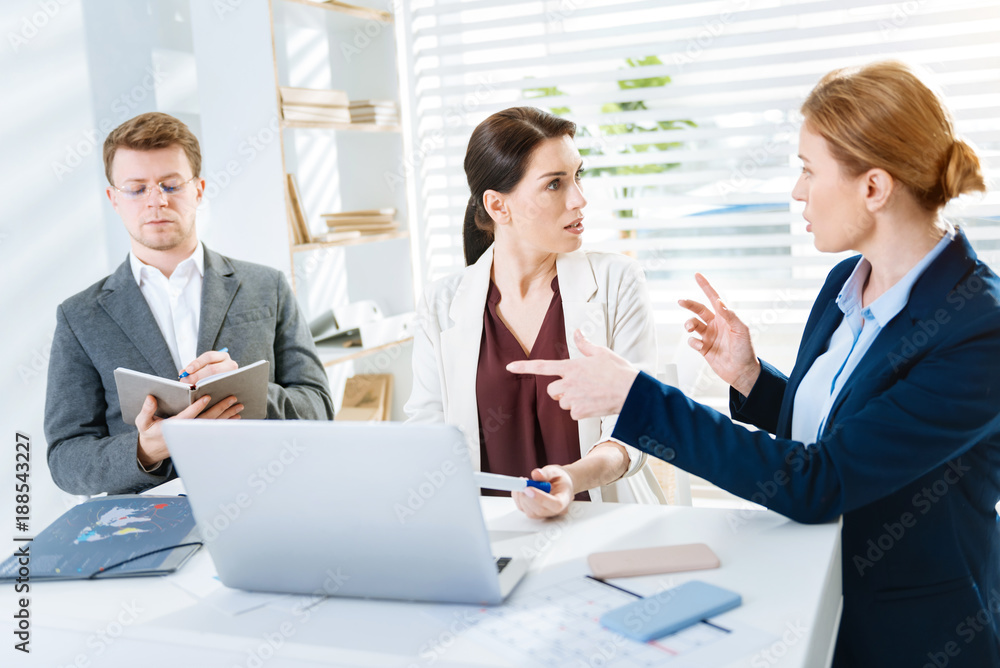Sharp point. Ambitious professional three colleagues have argue and woman gesturing while explaining her idea Sharp point. Ambitious professional three colleagues have argue and woman gesturing while explaining her idea