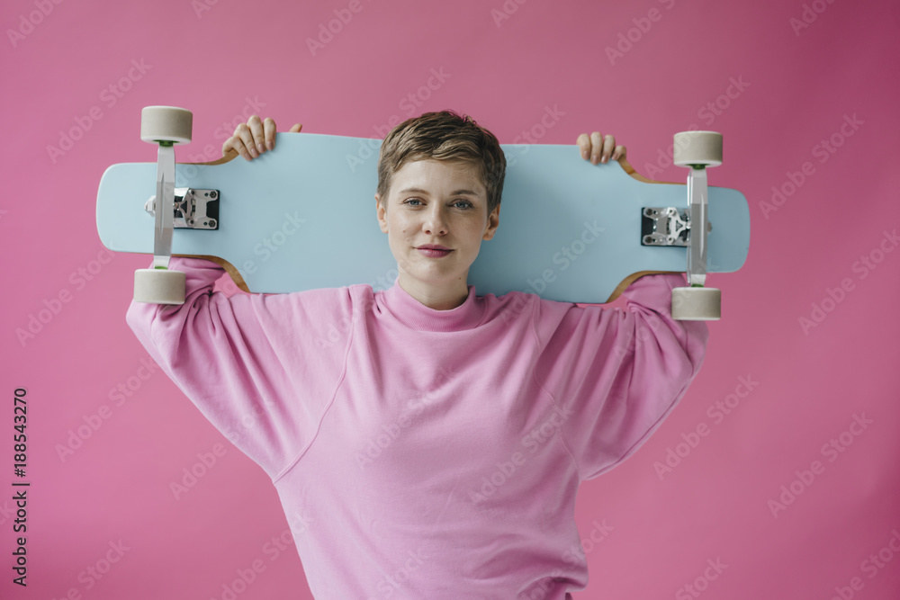 Portrait of woman in pink holding skateboard Portrait of woman in pink holding skateboard