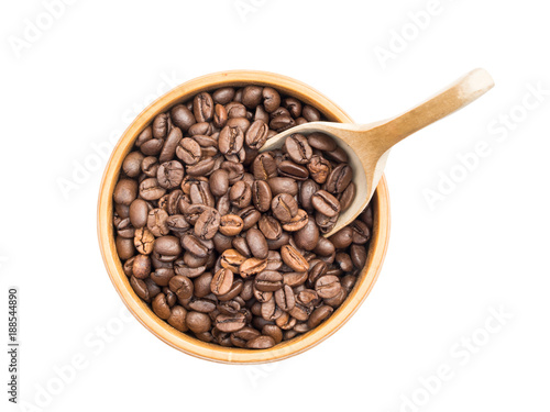 Coffee beans in a wooden bowl with a spoon seen from above isolated on white background