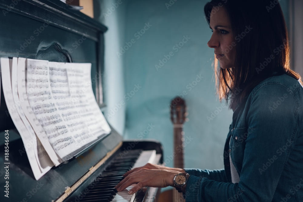 Side view of a beautiful woman playing piano Stock Photo | Adobe Stock