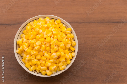 Canned sweet corn in a bowl on wooden table