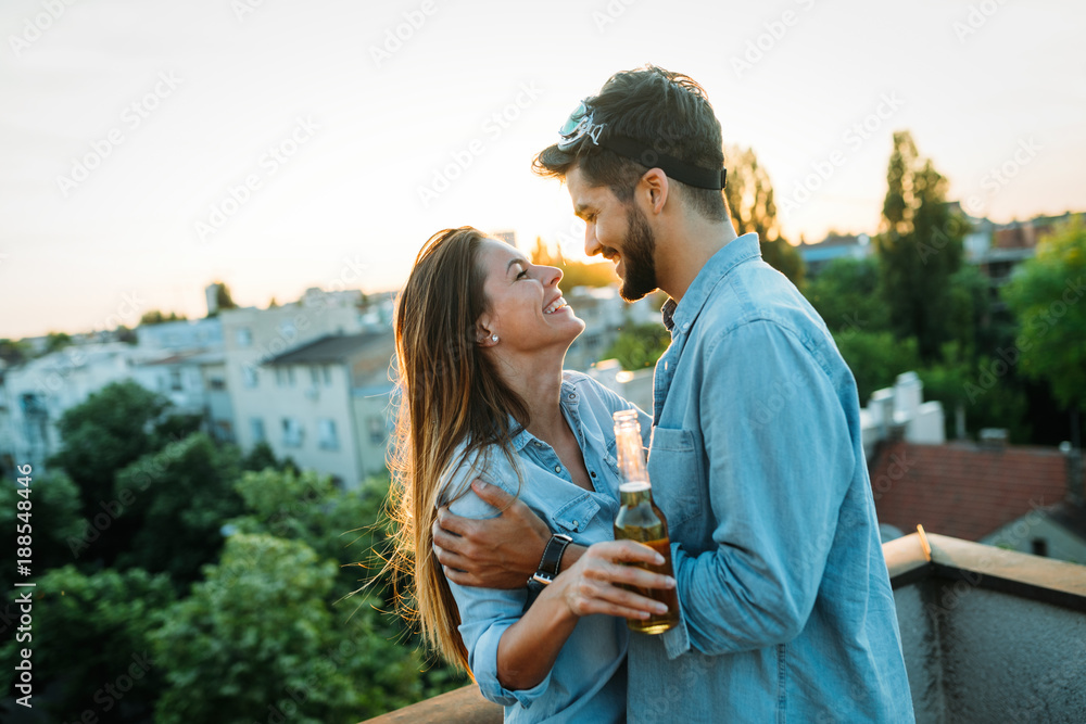 Happy couple enjoying drinks and balcony
