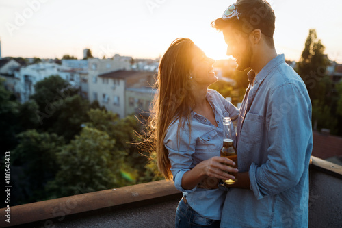 Happy couple enjoying drinks and balcony photo