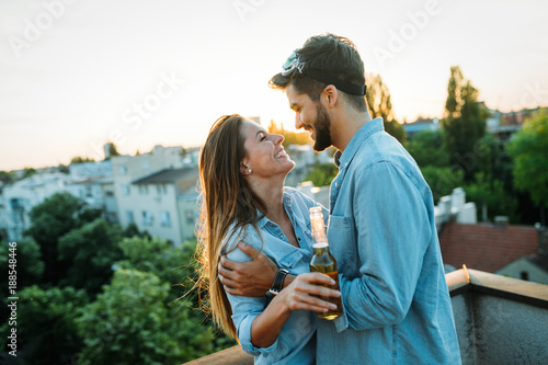 Happy couple enjoying drinks and balcony photo