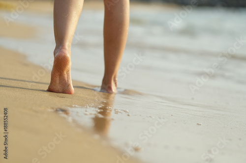 girl barefoot walking on the beach