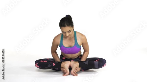 Young attractive woman practicing yoga doing Mulabandhasana, The Root Lock Pose in full length, isolated over white studio background photo