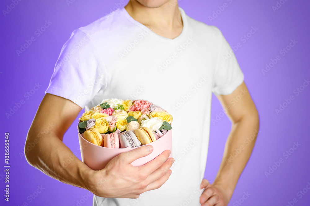 Man holding flowers and cookies in a box. Hands holding rocket in a hatbox Man holding flowers and cookies in a box. Hands holding rocket in a hatbox