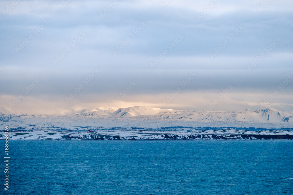 Beautiful view and winter Landscape picture of Iceland winter season with snow-capped mountain in the background and sea in the foreground Beautiful view and winter Landscape picture of Iceland winter season with snow-capped mountain in the background and sea in the foreground