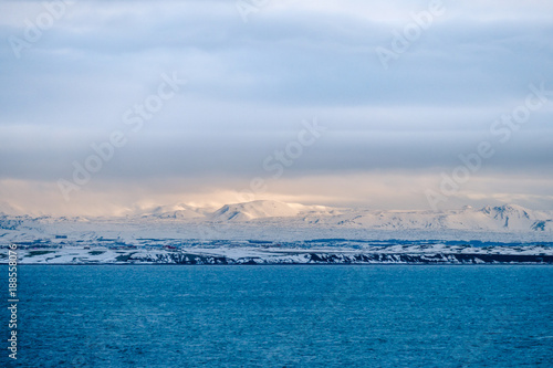 Beautiful view and winter Landscape picture of Iceland winter season with snow-capped mountain in the background and sea in the foreground