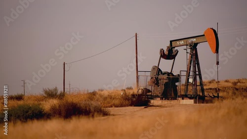 November 23, 2017. Southern California, United States. Working Lufkin Pumpjack Oil Pump on the Grassy Prairie photo
