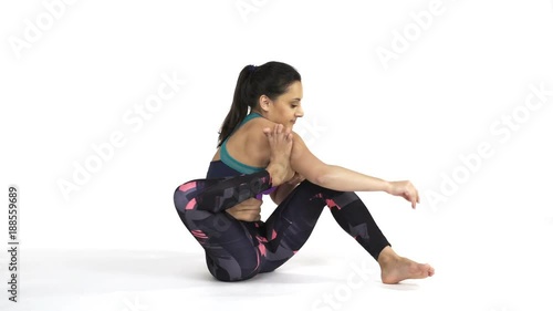 Young attractive woman practicing yoga doing Ekapada Yogadandasana Pose in full length, isolated over white studio background photo