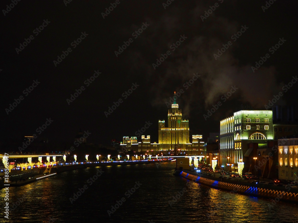 view night on the river, a residential skyscraper on Kotelnicheskaya Embankment, Moscow River, Bolshoy Ustinsky bridge. Moscow, Russia