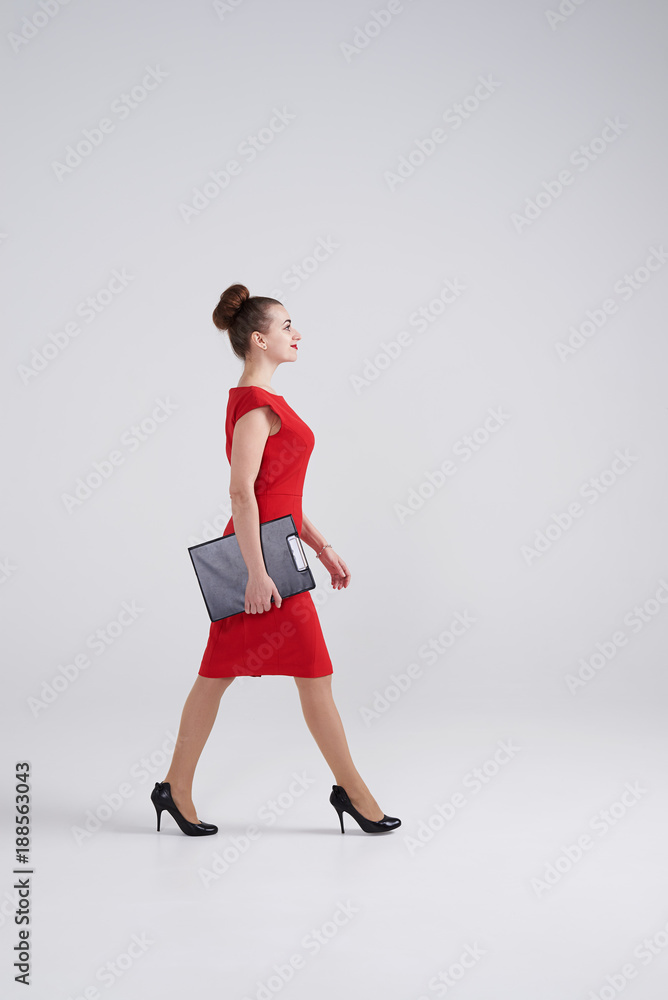 Businesswoman walking and holding folder in hands Businesswoman walking and holding folder in hands