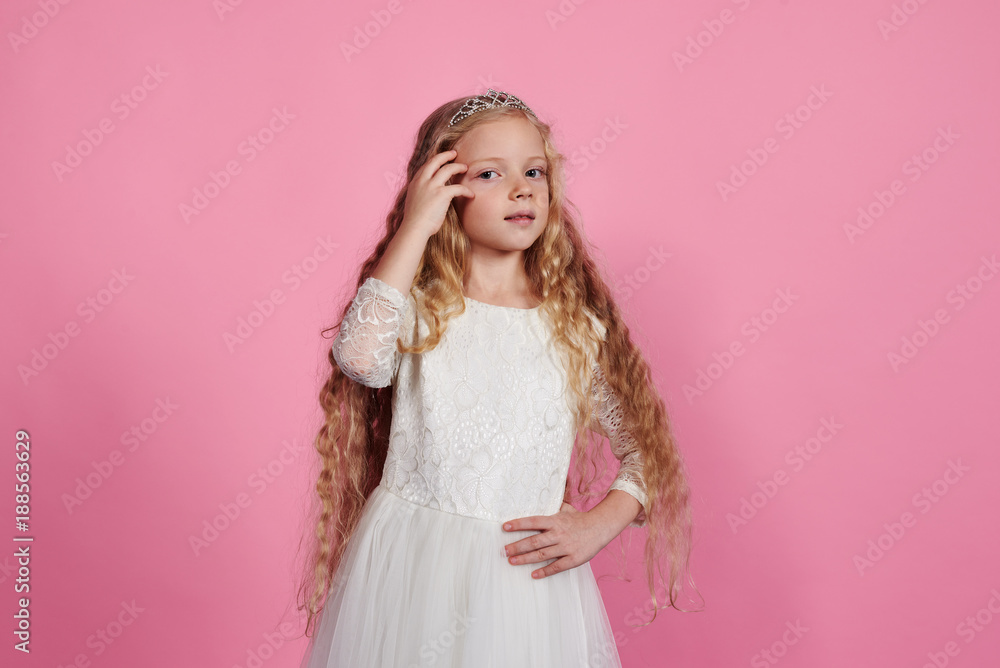 Blonde little girl posing in white dress and diadem Blonde little girl posing in white dress and diadem