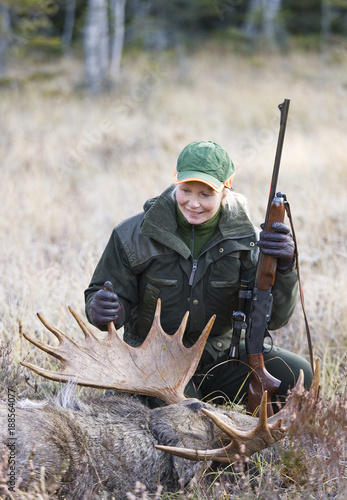 Hunter posing beside dead moose