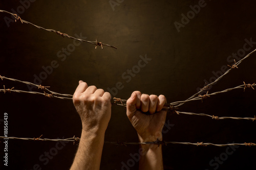 Man Be Handing Fence from Barbed Wire