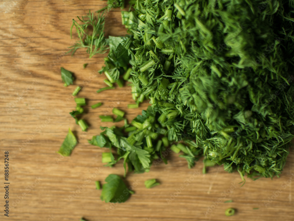 finely chopped greens on a chopping board. finely chopped greens on a chopping board.