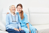 Pflegehilfe und lachende  glückliche Seniorin
