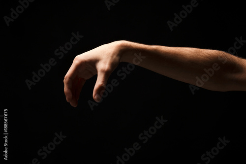 Male hand picking up something, cutout on black