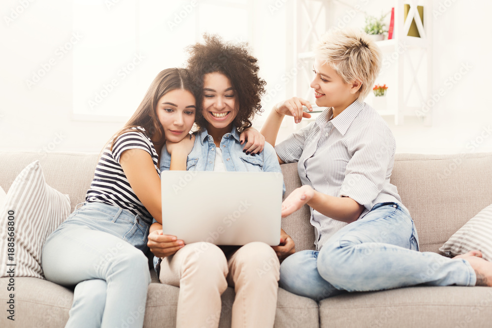 Three happy beautiful women using laptop at home Three happy beautiful women using laptop at home
