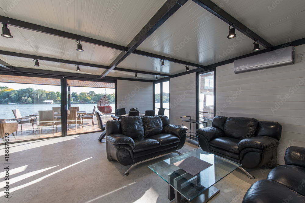 Fototapeta premium Leather sofas in luxury cottage by river