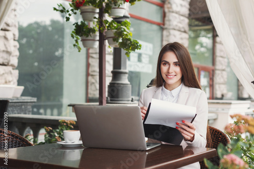 Beautiful businesswoman working with papers outdoors
