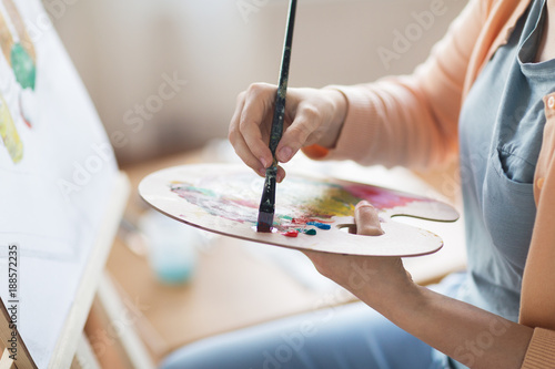 artist with palette painting at art studio