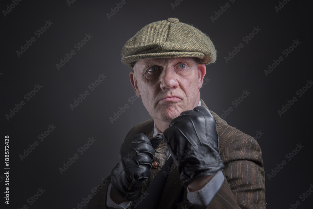 Portrait of a mature gangster with his fists up ready to punch, taken with copy space 