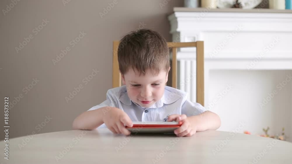 The child enthusiastically plays on the phone The child enthusiastically plays on the phone